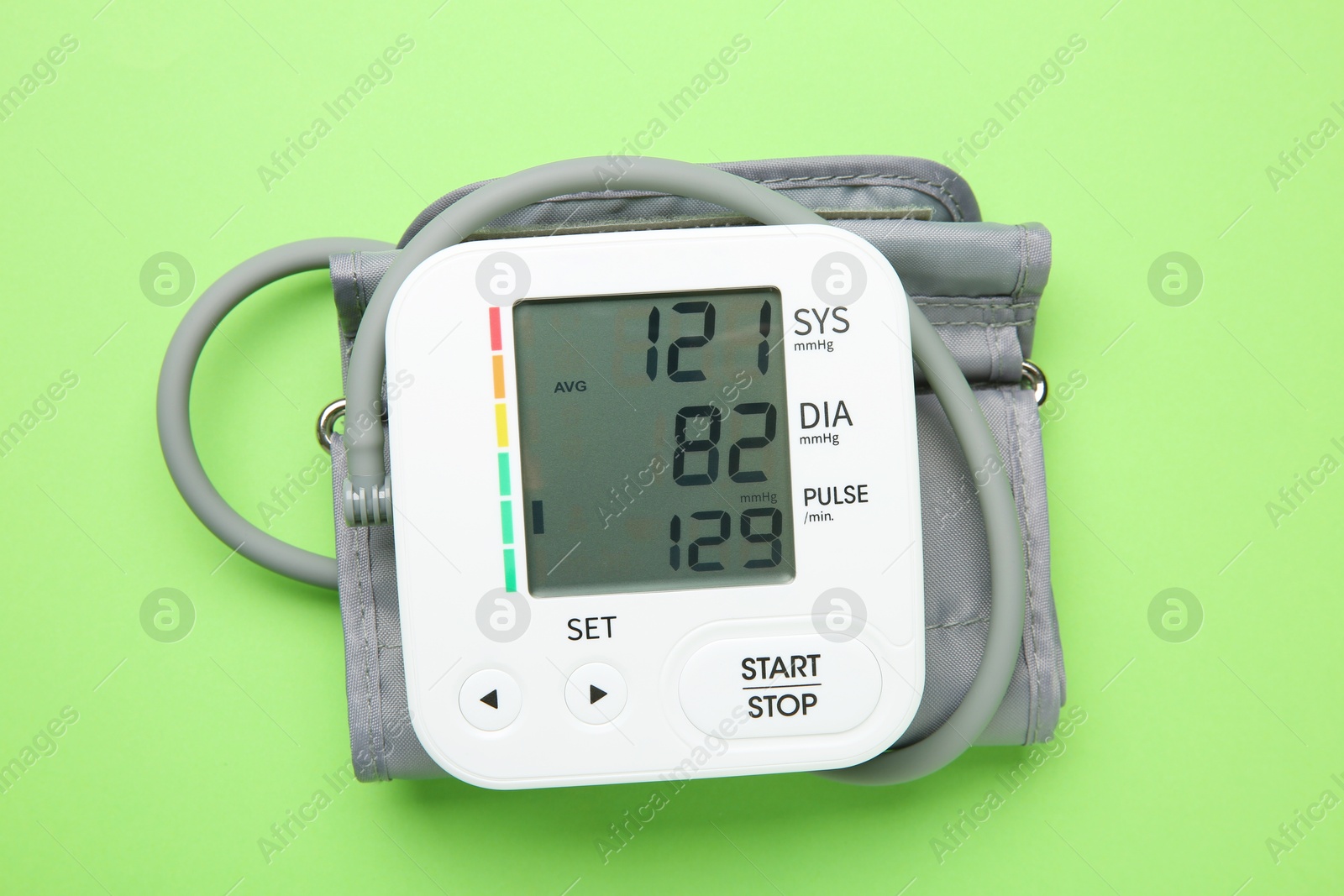 Photo of Blood pressure measuring device on green background, top view