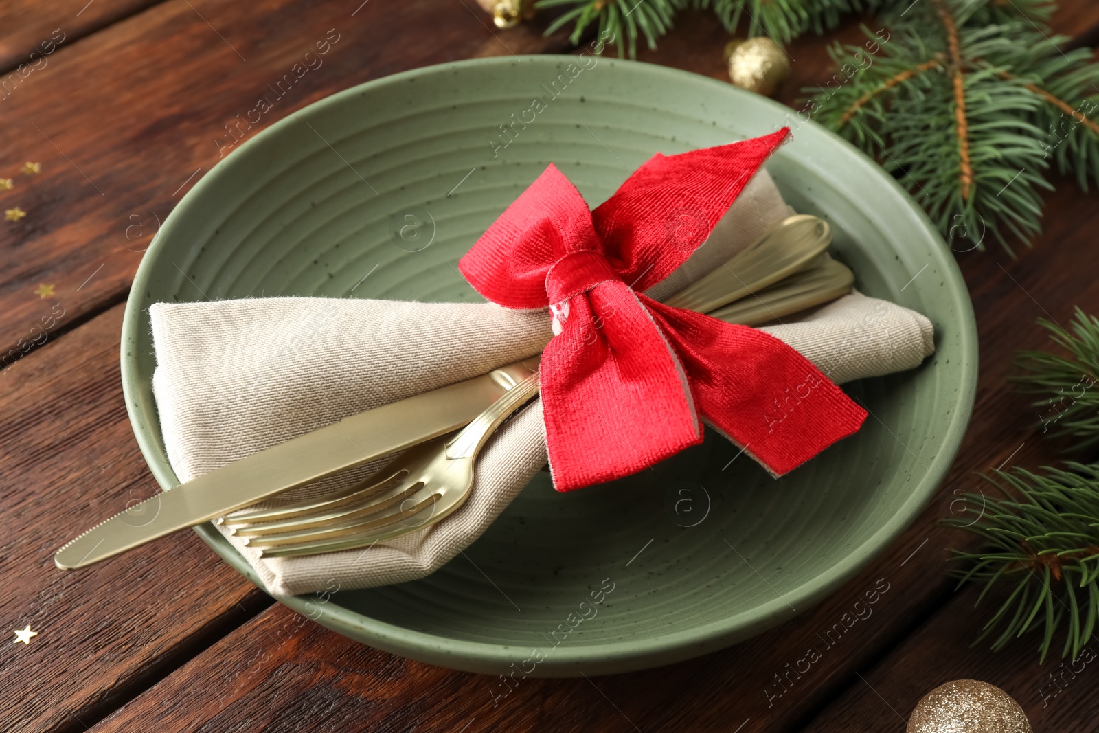 Photo of Christmas setting and festive decor on wooden table, closeup