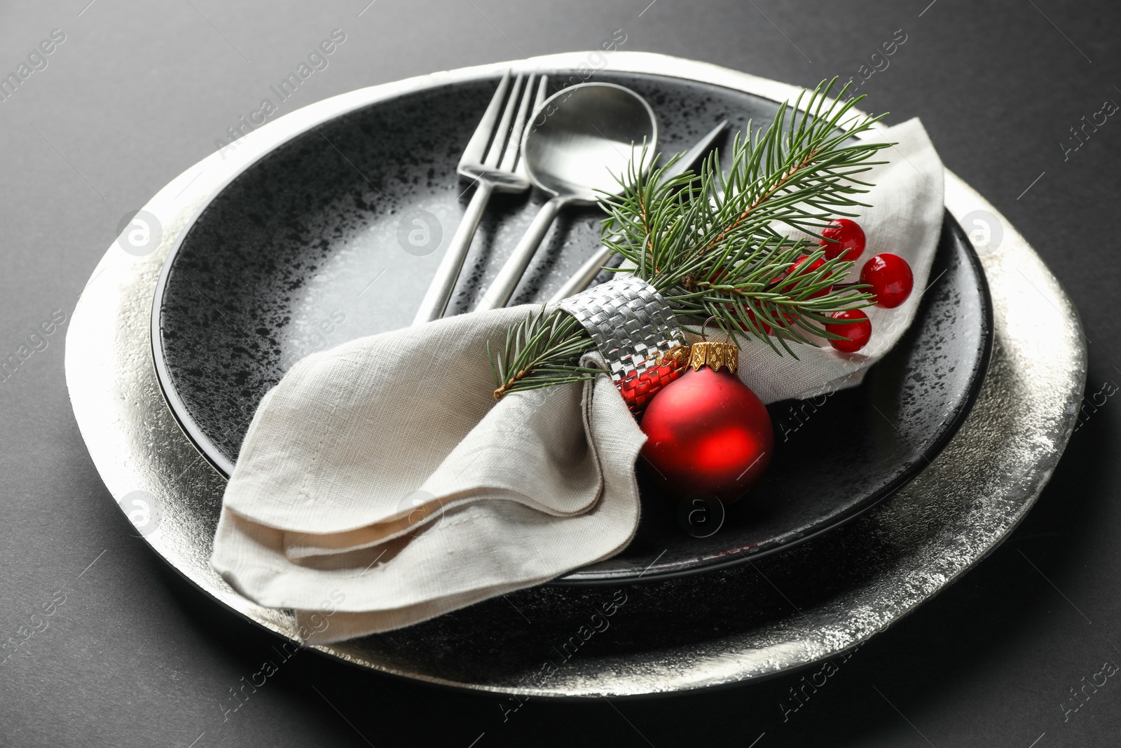 Photo of Christmas setting with festive decor on dark table, closeup