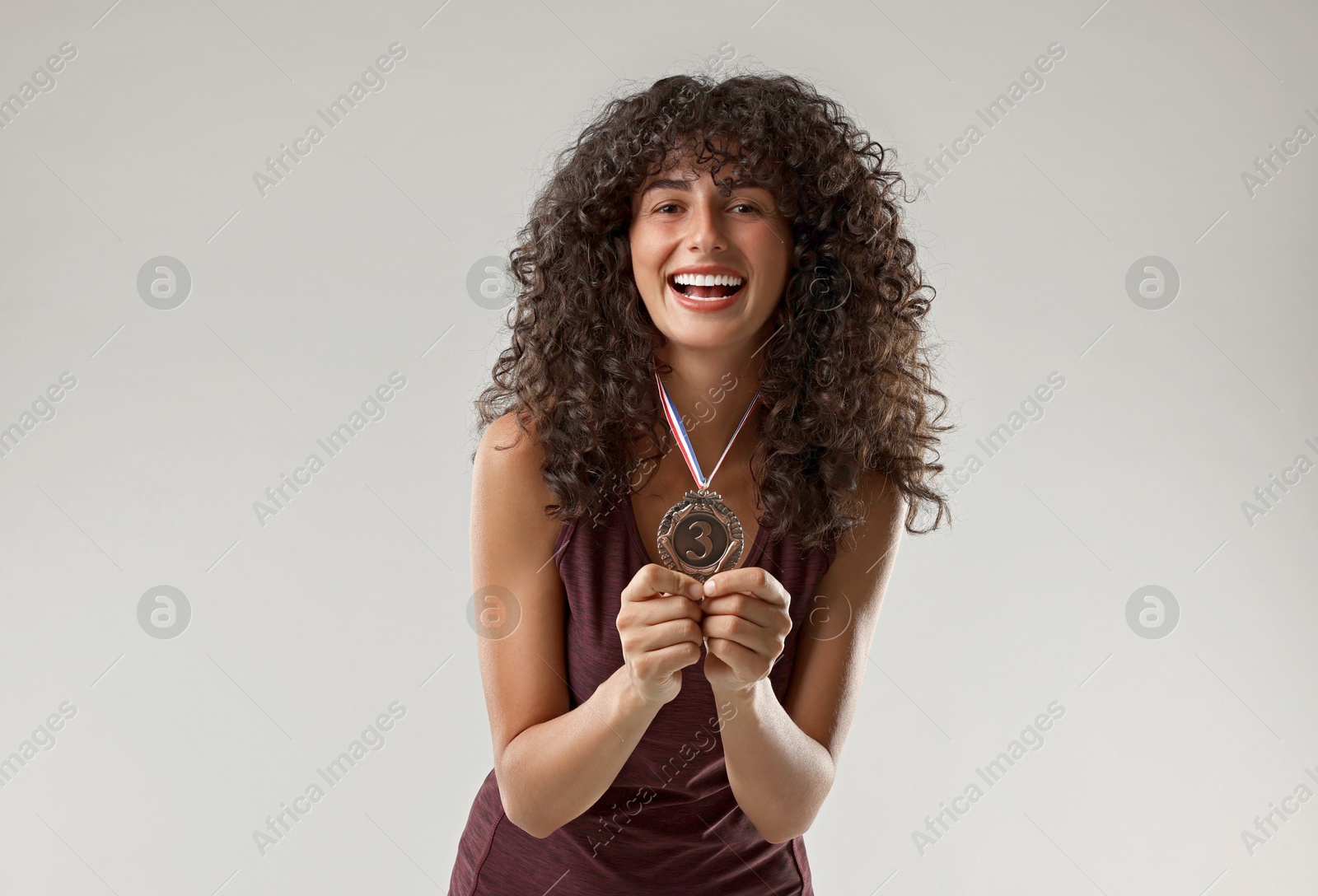 Photo of Happy winner with bronze medal on light grey background