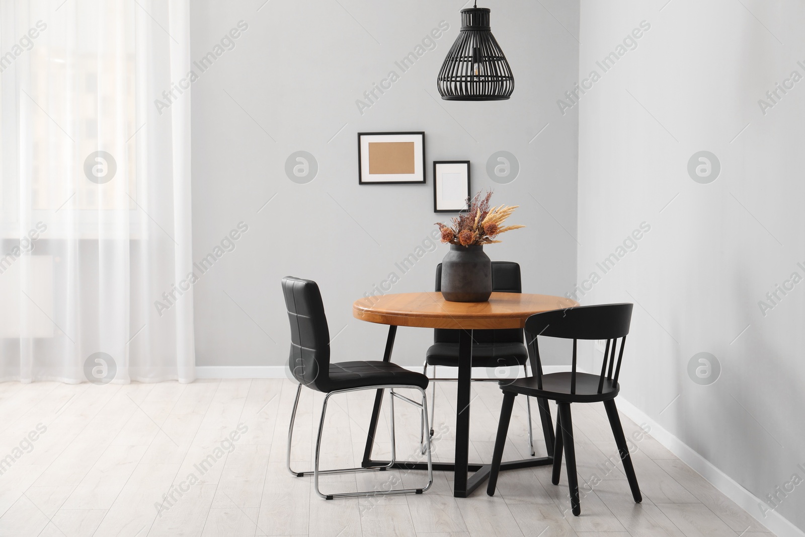 Photo of Wooden table with black chairs in stylish dining room