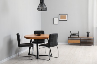 Photo of Wooden table with black chairs in stylish dining room