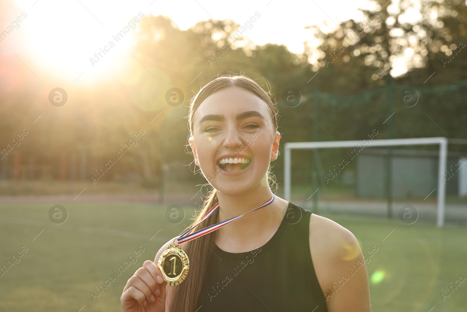 Photo of Happy winner with golden medal at stadium