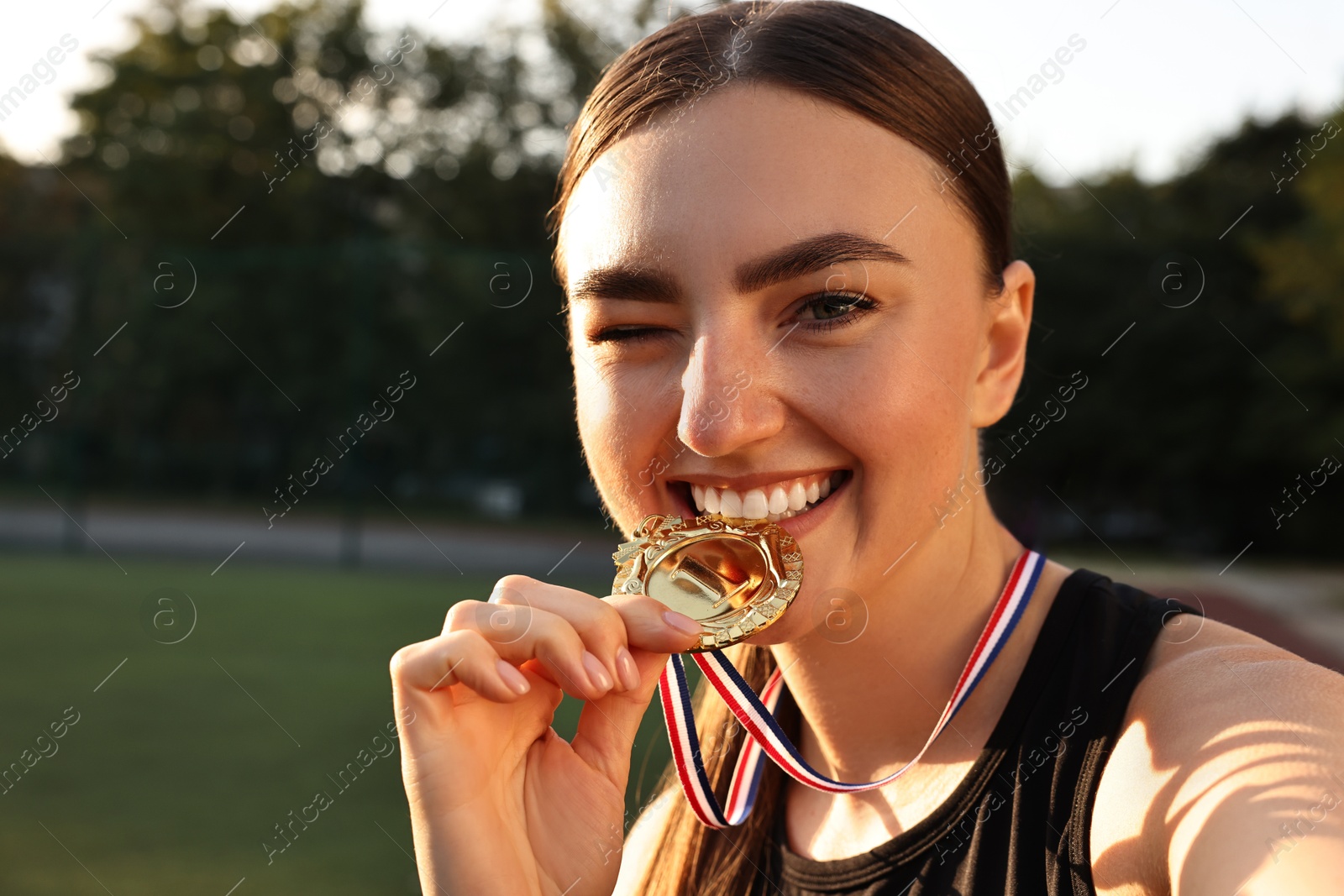 Photo of Happy winner with golden medal at stadium