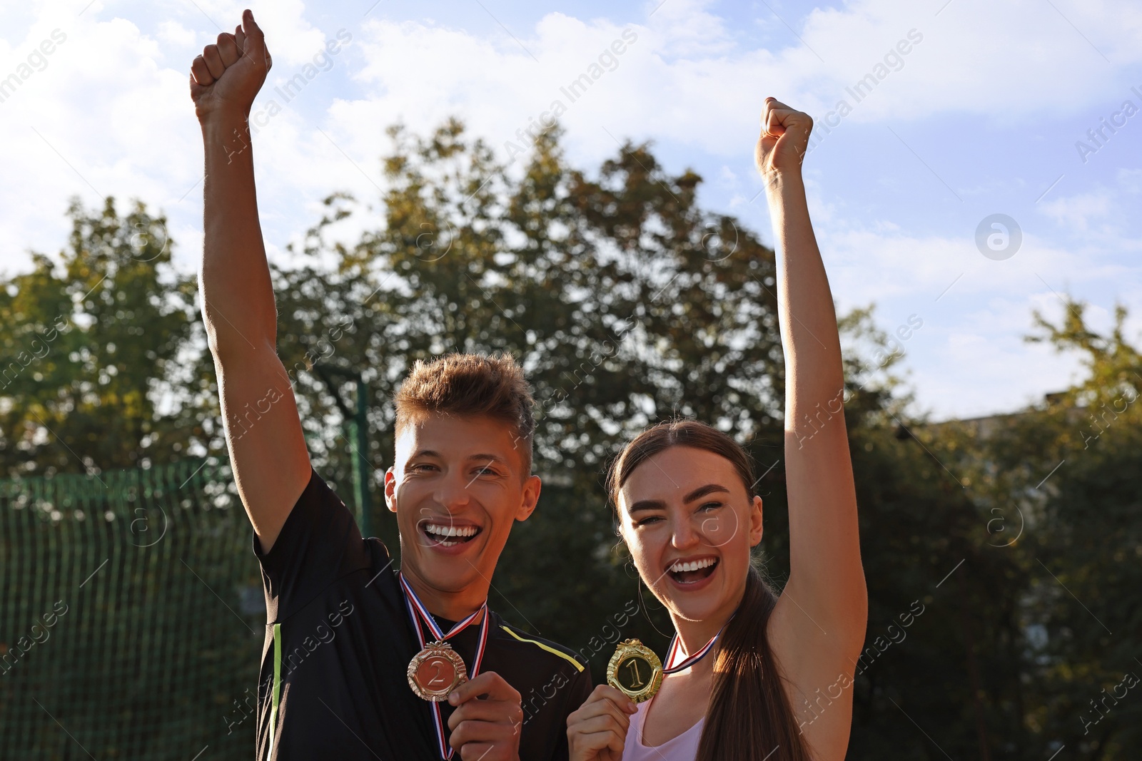 Photo of Portrait of happy winners with medals outdoors