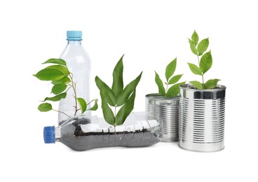 Photo of Recycling concept. Plastic bottles and cans with plants isolated on white