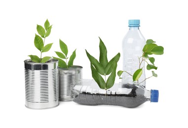 Photo of Recycling concept. Plastic bottles and cans with plants isolated on white