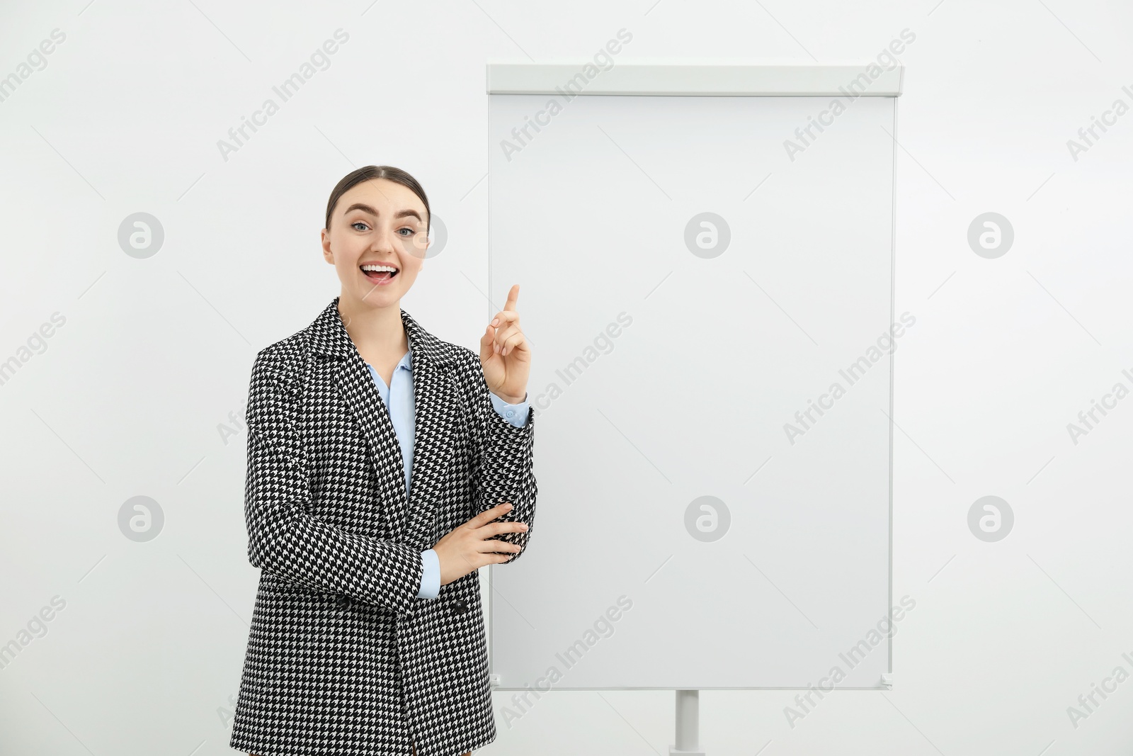 Photo of Happy woman near flip chart on white background. Mockup for design