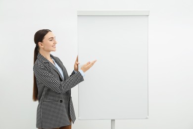 Photo of Happy woman near flip chart on white background. Mockup for design