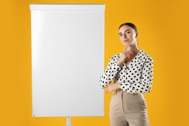 Woman near flip chart on orange background. Mockup for design