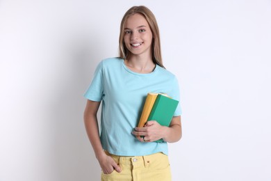 Teenage girl with books on white background