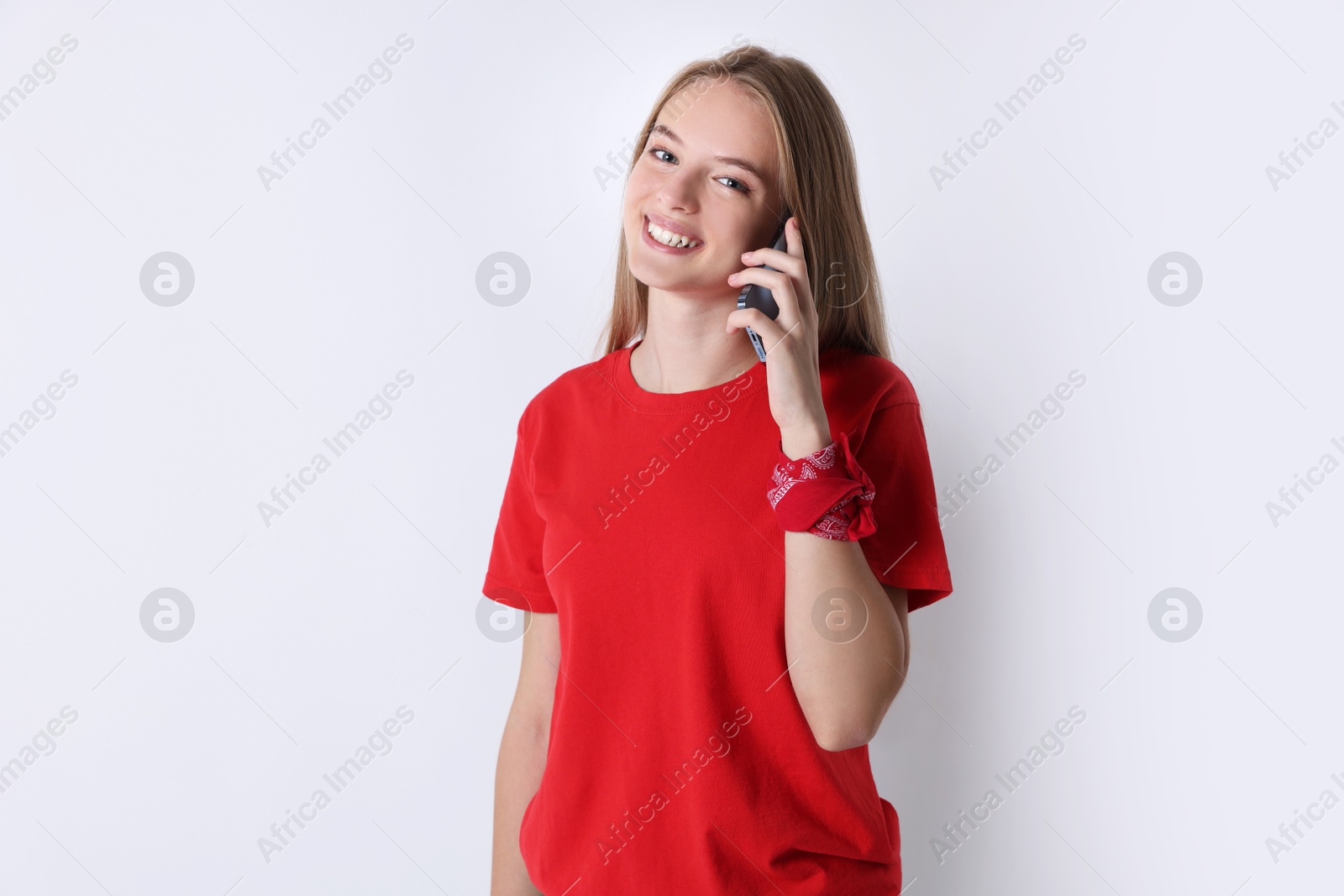 Photo of Teenage girl talking on smartphone against white background