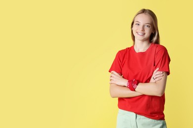 Portrait of teenage girl on yellow background, space for text