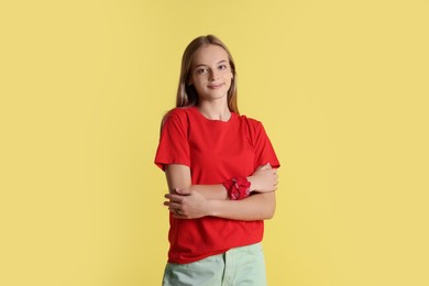 Portrait of teenage girl on yellow background