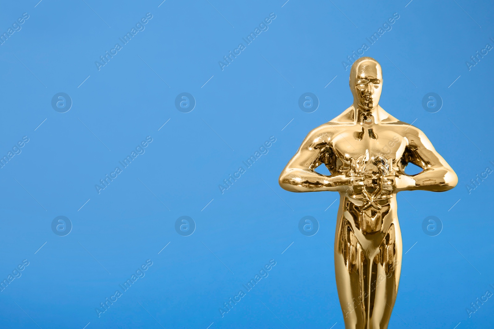 Photo of Golden trophy in shape of human figure on blue background, space for text