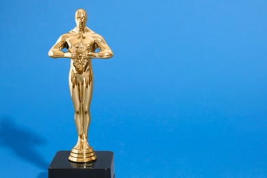 Photo of Golden trophy in shape of human figure on blue background, space for text