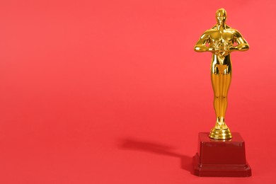 Photo of Golden trophy in shape of human figure on red background, space for text