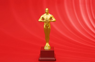 Photo of Golden trophy in shape of human figure on red background