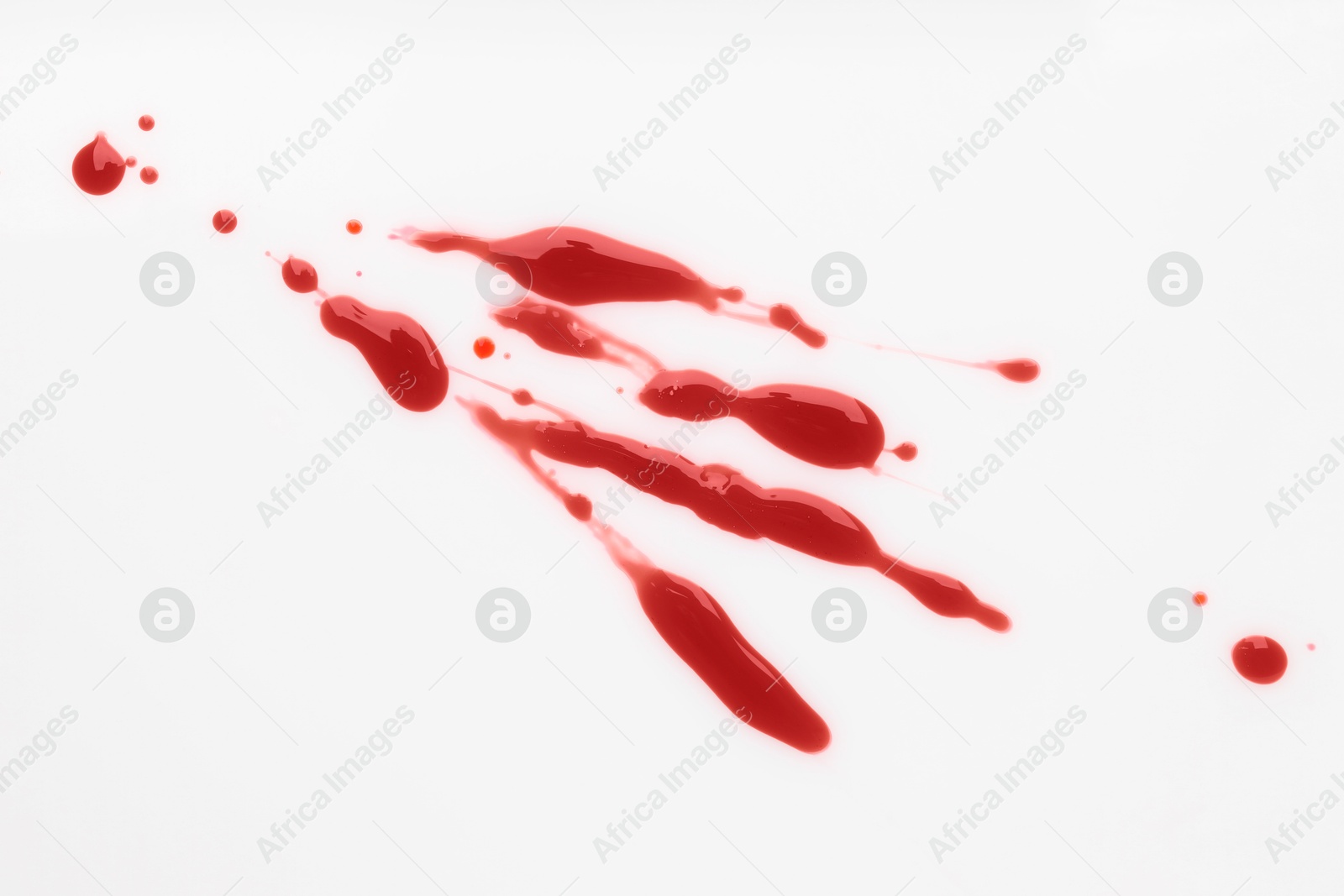 Photo of Splashes of blood on white background, top view