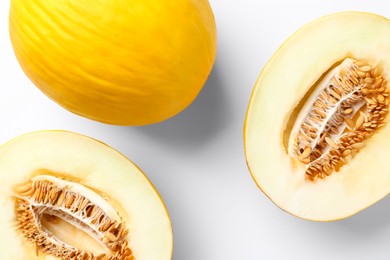 Photo of Fresh whole and cut melons on white background, flat lay