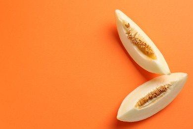 Photo of Fresh cut melon on orange background, top view. Space for text