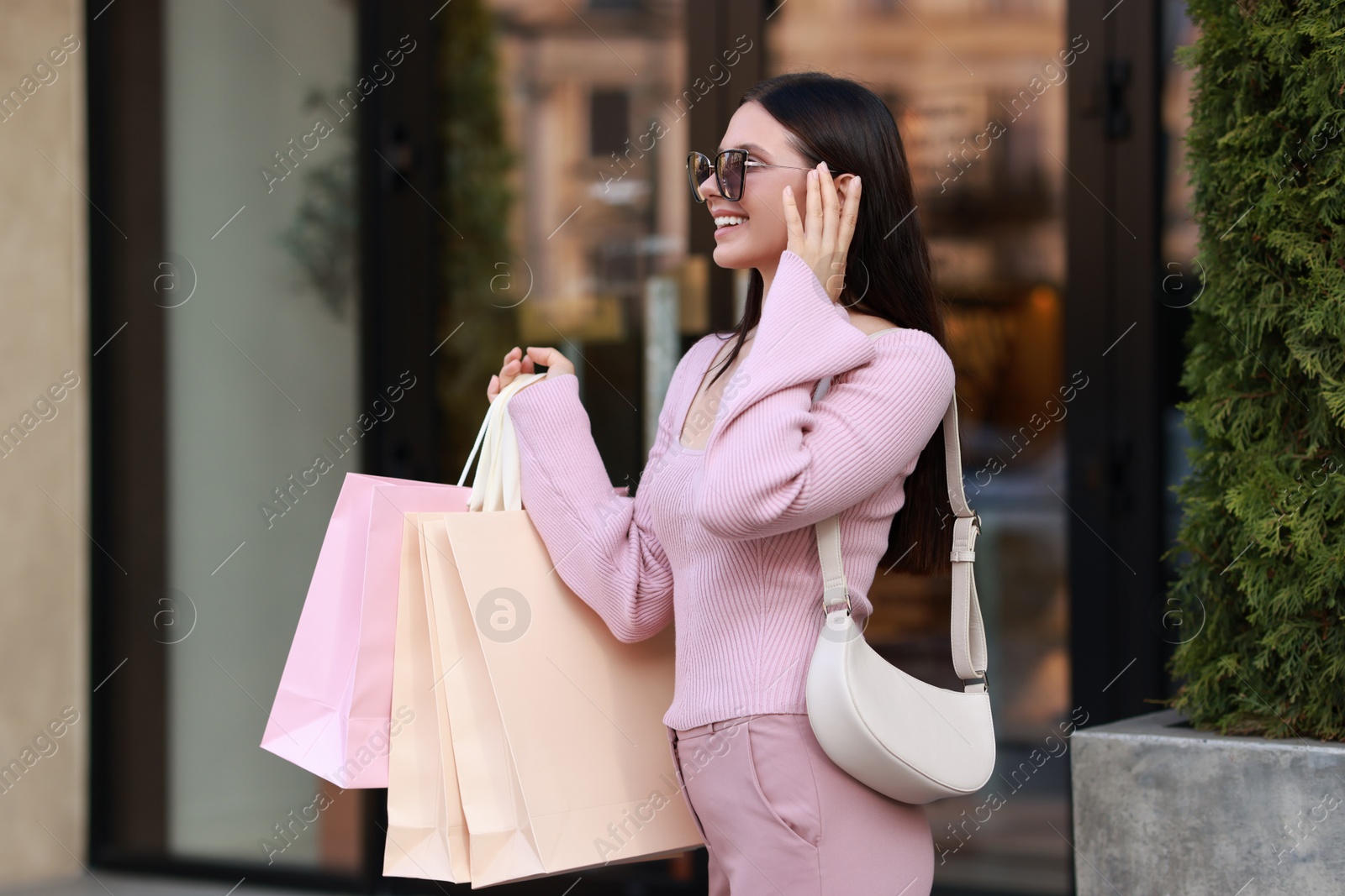 Photo of Happy woman with colorful shopping bags outdoors