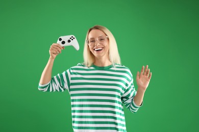 Happy woman with controller on green background