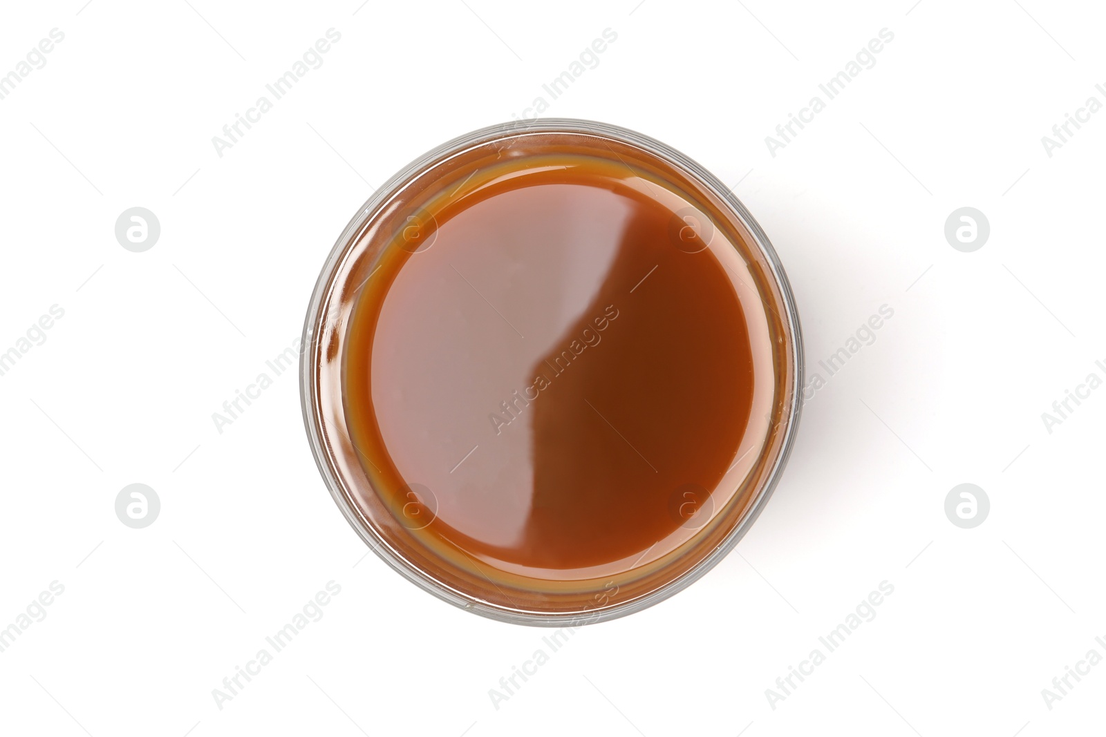 Photo of Tasty caramel sauce in glass bowl isolated on white, top view