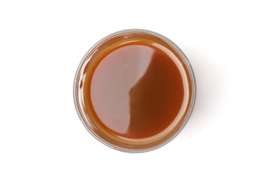 Photo of Tasty caramel sauce in glass bowl isolated on white, top view