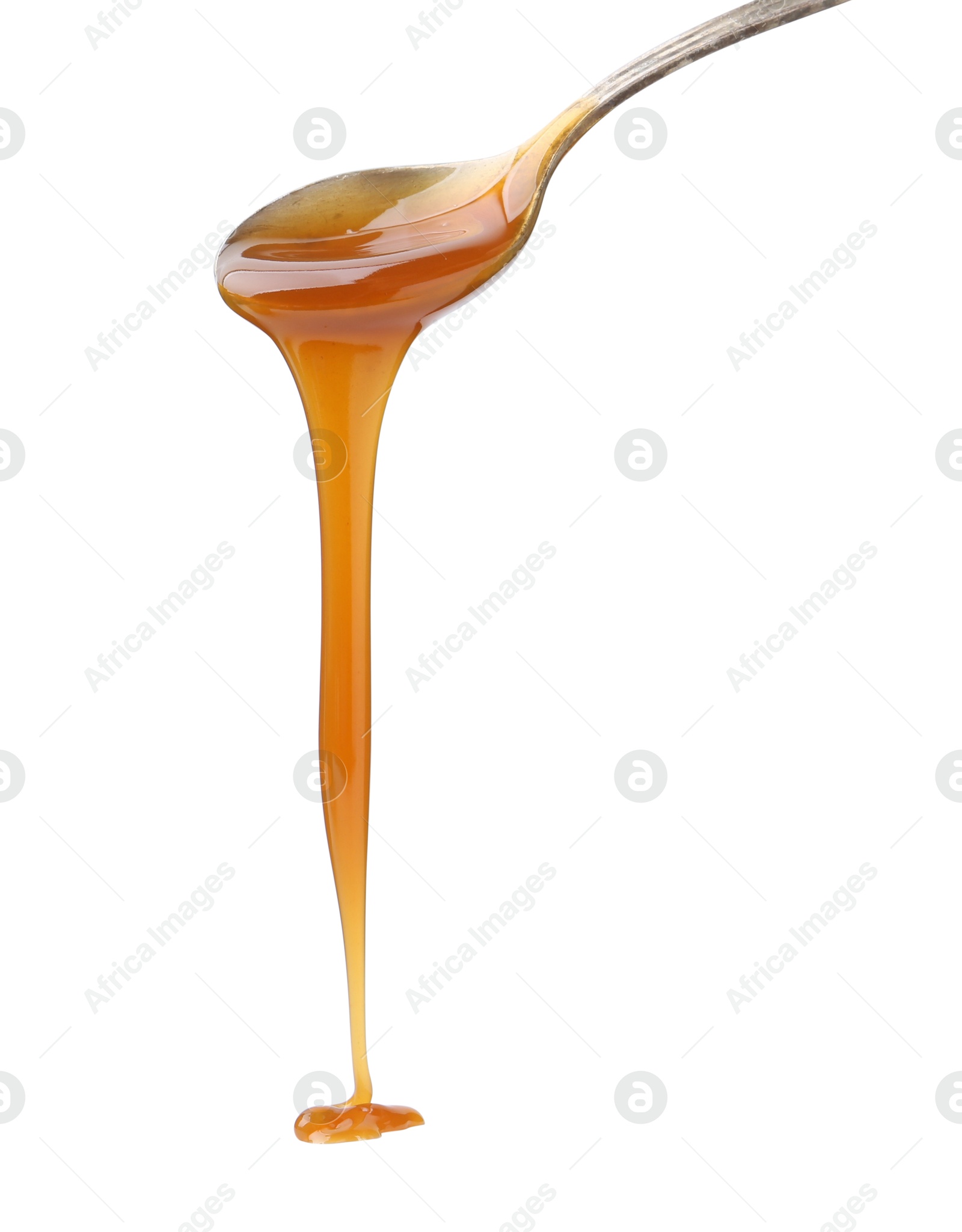 Photo of Tasty caramel sauce dripping from spoon on white background, closeup