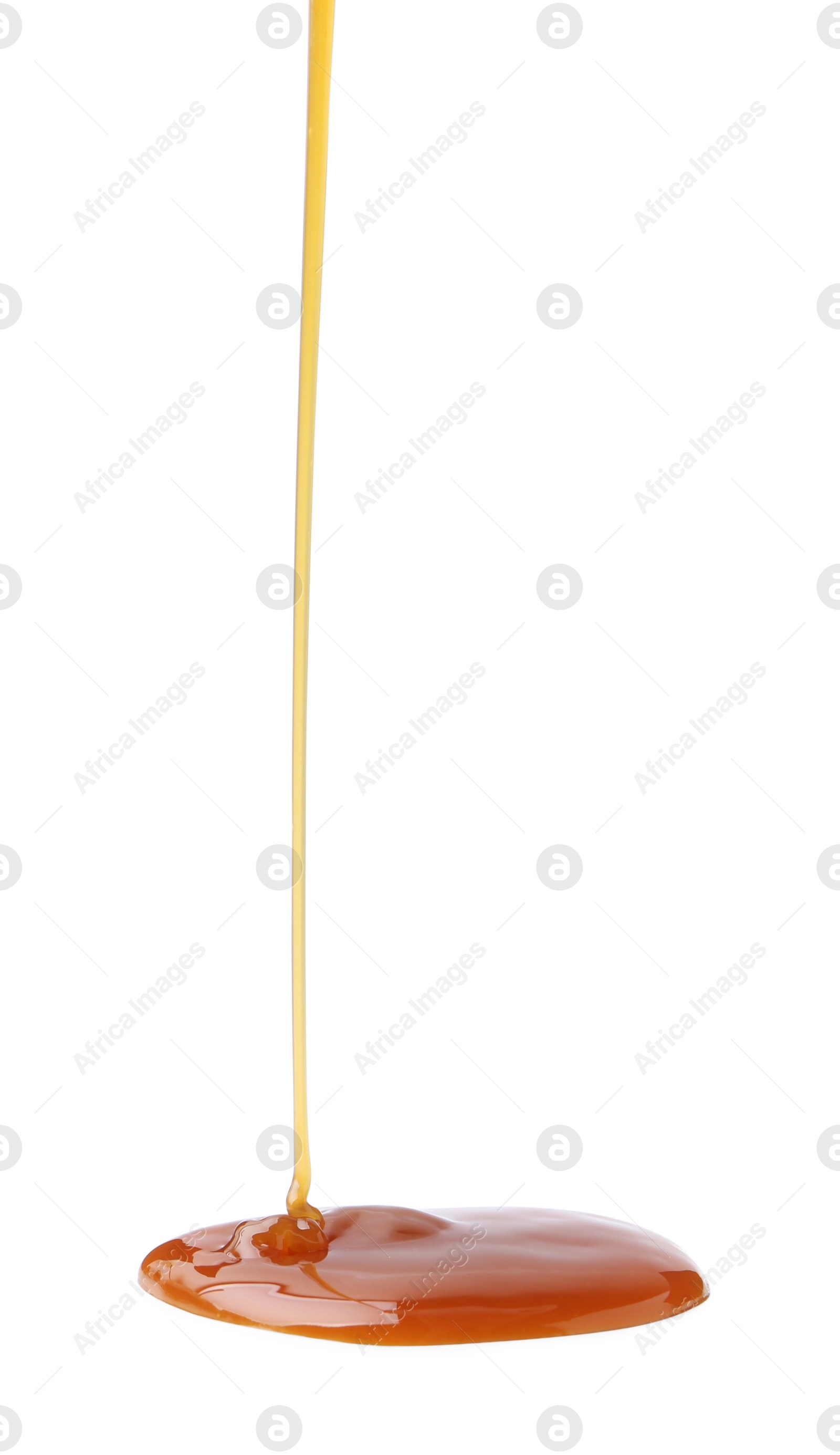 Photo of Tasty caramel sauce dripping on white background, closeup