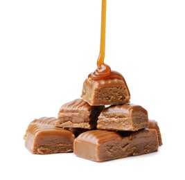 Photo of Caramel sauce dripping onto candies on white background, closeup