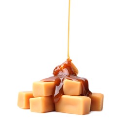 Photo of Caramel sauce dripping onto candies on white background, closeup