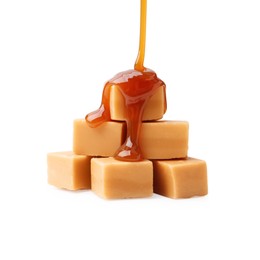 Photo of Caramel sauce dripping onto candies on white background, closeup