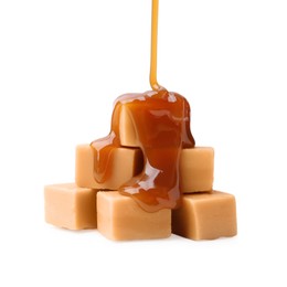 Photo of Caramel sauce dripping onto candies on white background, closeup