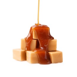 Photo of Caramel sauce dripping onto candies on white background, closeup