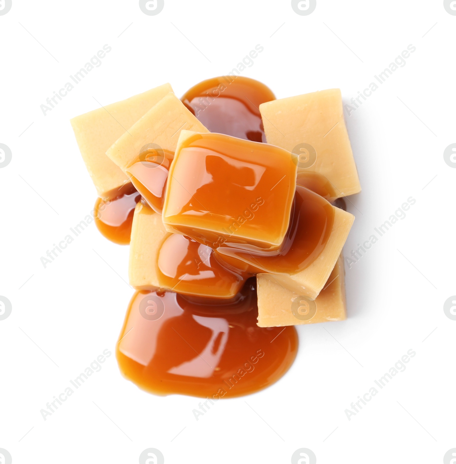 Photo of Tasty candies with caramel sauce isolated on white, top view