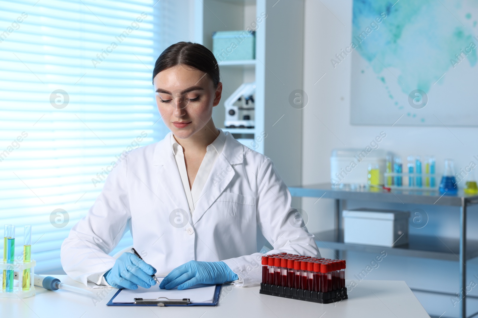 Photo of Laboratory testing. Doctor working at table with blood samples indoors