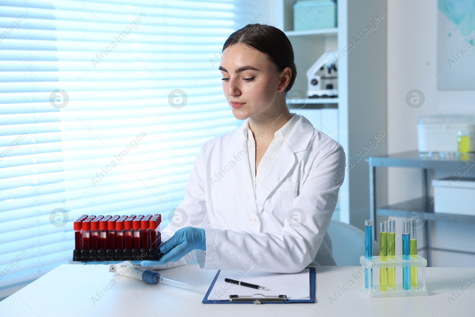 Photo of Laboratory testing. Doctor with blood samples at table indoors