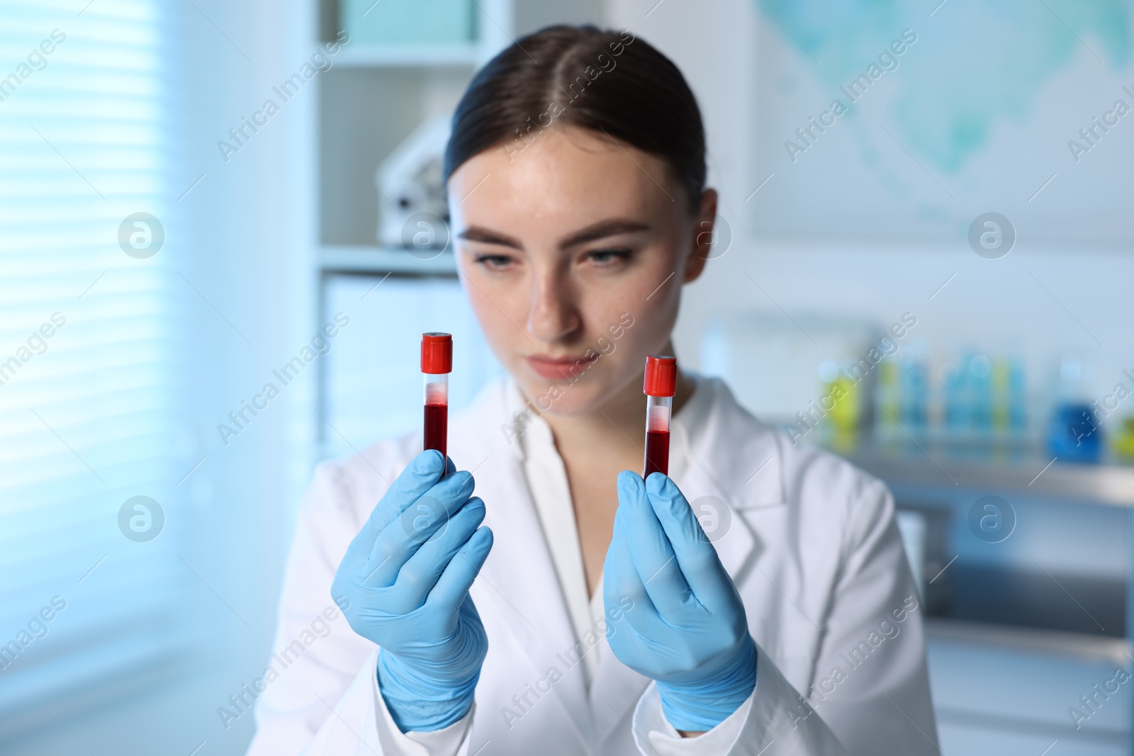 Photo of Laboratory testing. Doctor holding test tubes with blood samples indoors, selective focus