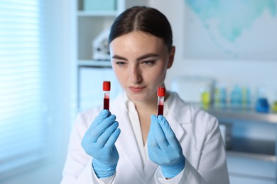 Laboratory testing. Doctor holding test tubes with blood samples indoors, selective focus