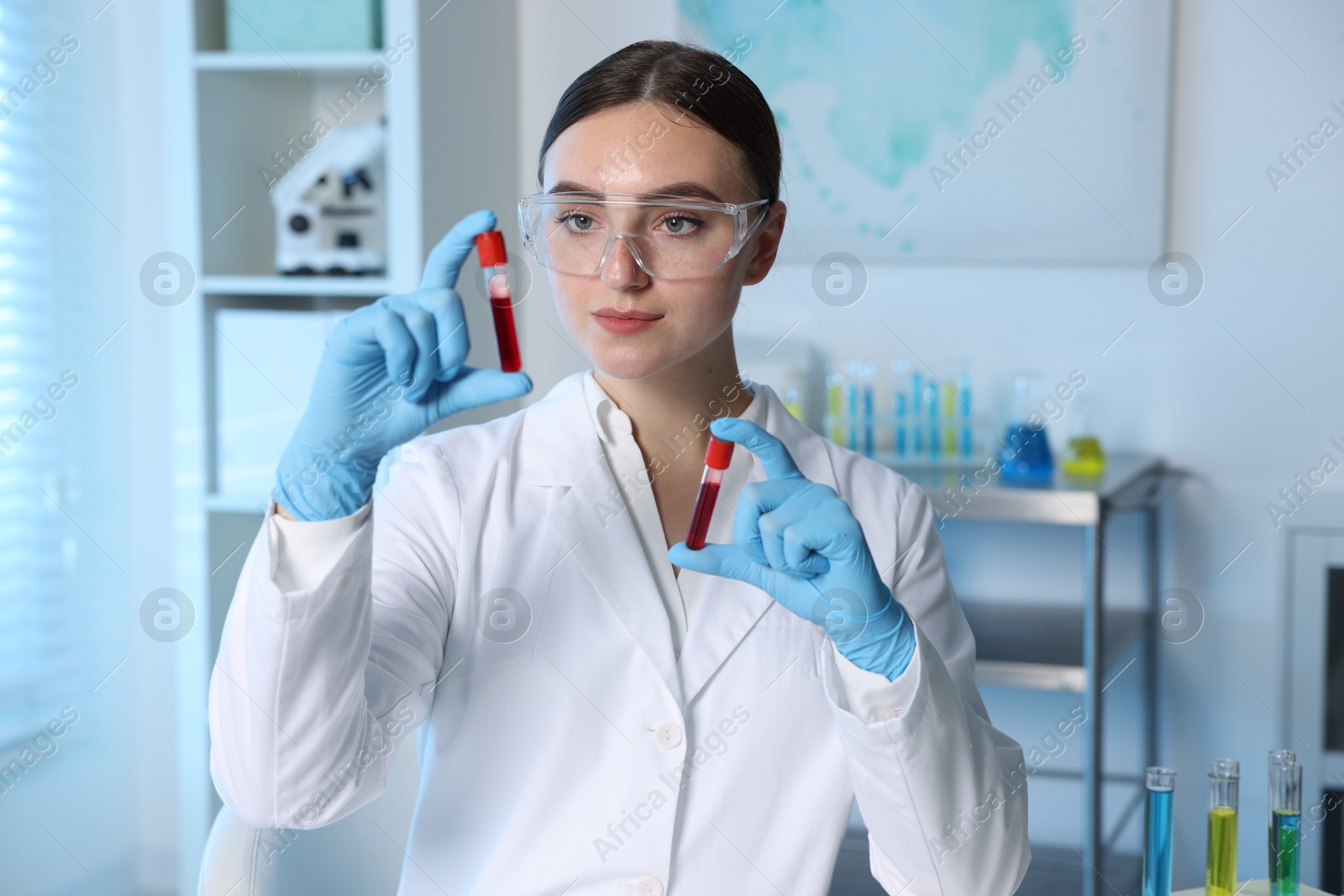 Photo of Laboratory testing. Doctor holding test tubes with blood samples indoors