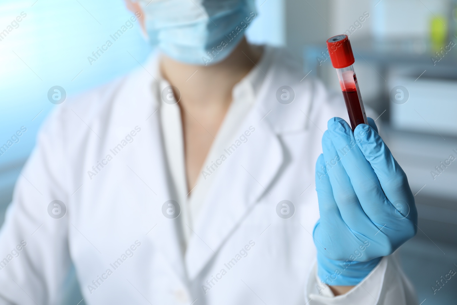 Photo of Laboratory testing. Doctor holding test tube with blood sample indoors, closeup