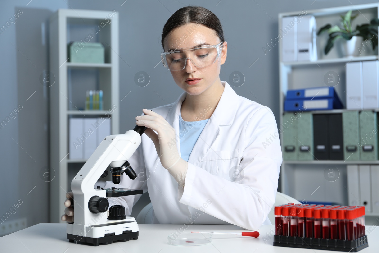 Photo of Laboratory testing. Doctor working with microscope at table indoors