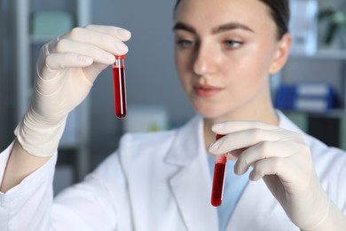 Laboratory testing. Doctor holding test tubes with blood samples indoors, selective focus