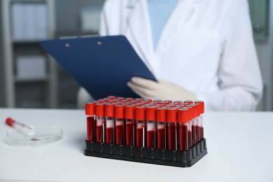 Laboratory testing. Doctor working at table indoors, focus on blood samples