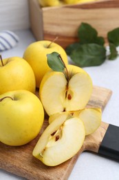 Photo of Ripe yellow apples on light grey table, closeup