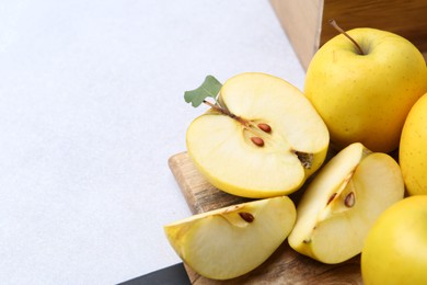 Photo of Ripe yellow apples on light grey table, closeup. Space for text