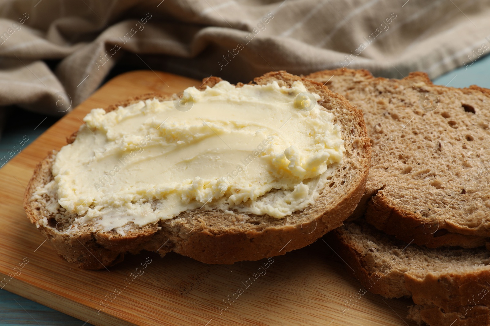 Fresh bread with butter on blue wooden table, closeup Photo of Fresh bread with butter on blue wooden table, closeup