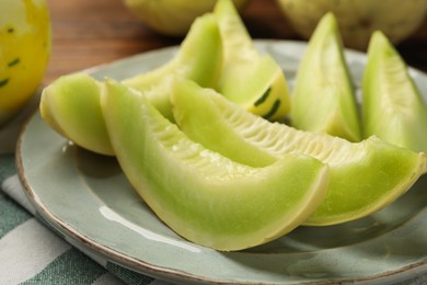 Photo of Plate with pieces of honeydew melon on table, closeup